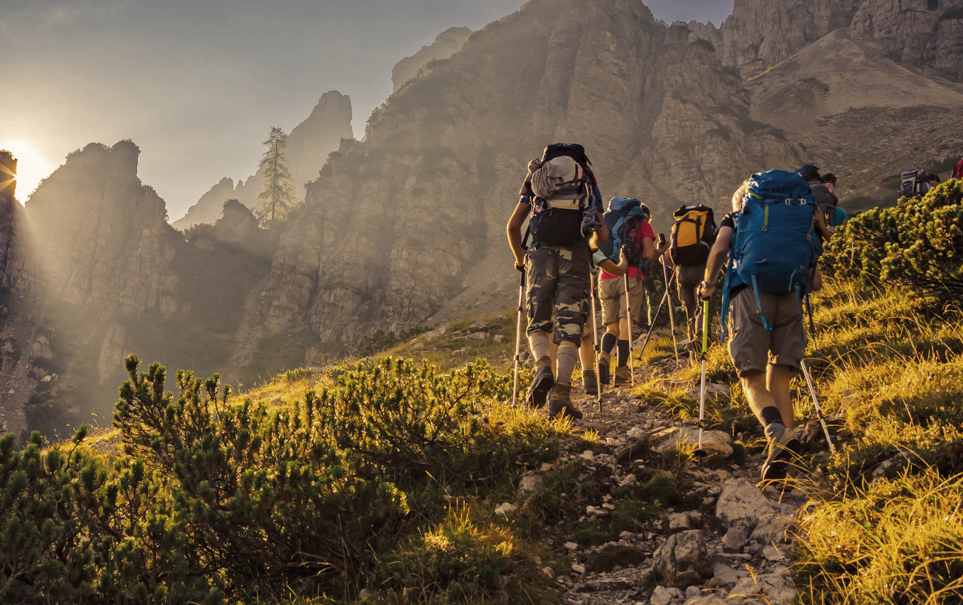 Some hikers go up a mountain path in the early hours of the day